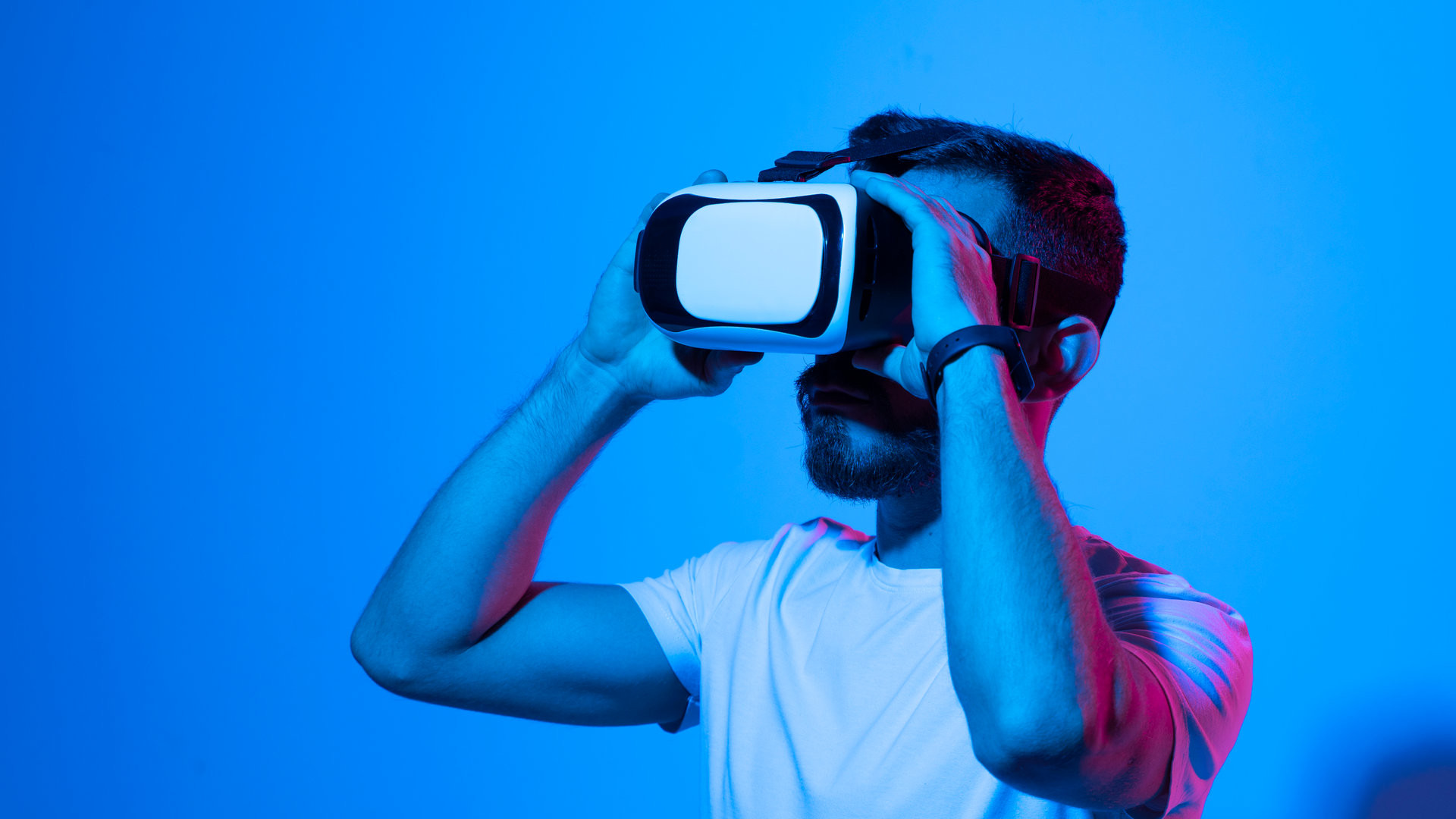 Portraite of young man gamer using virtual reality headset and playing favourite video games with a friends in metaverse. VR, future, gadgets, technology, education online, studying